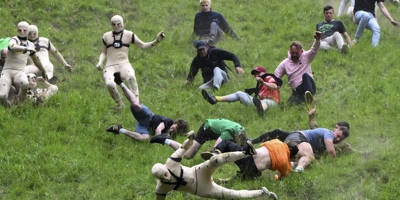 AP PHOTOS: Runners trip, stumble and roll their way to victory in annual downhill cheese chase